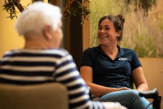 Fysiotherapeut in gesprek met een bewoner